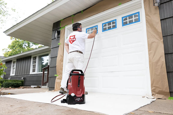 Titan Impact X 120 backpack sprayer being used to paint a garage door.